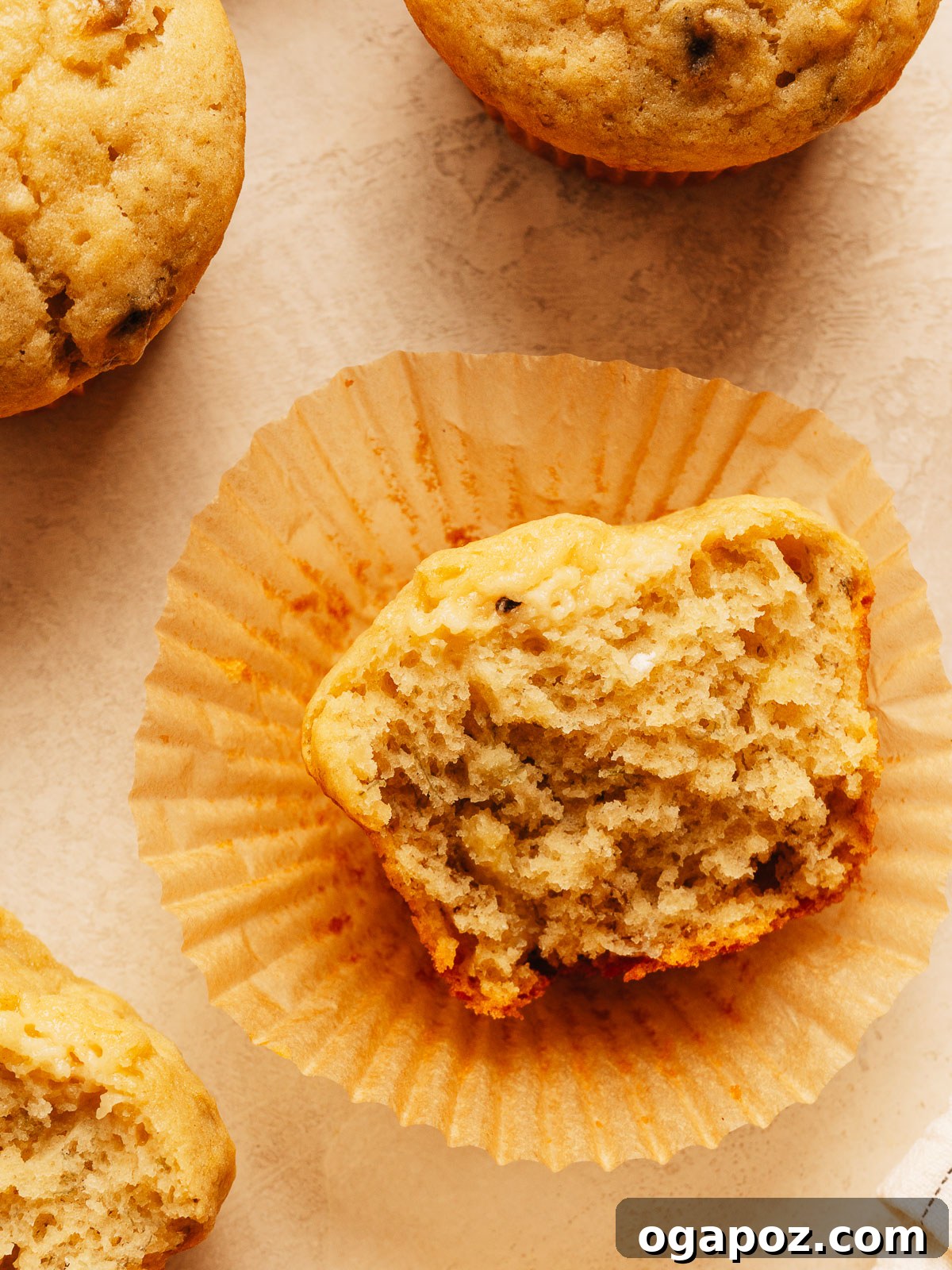 Moist Banana Bread Muffins That Stay Fresh for Days 7 A banana bread muffin split open to show the soft, moist crumb inside.