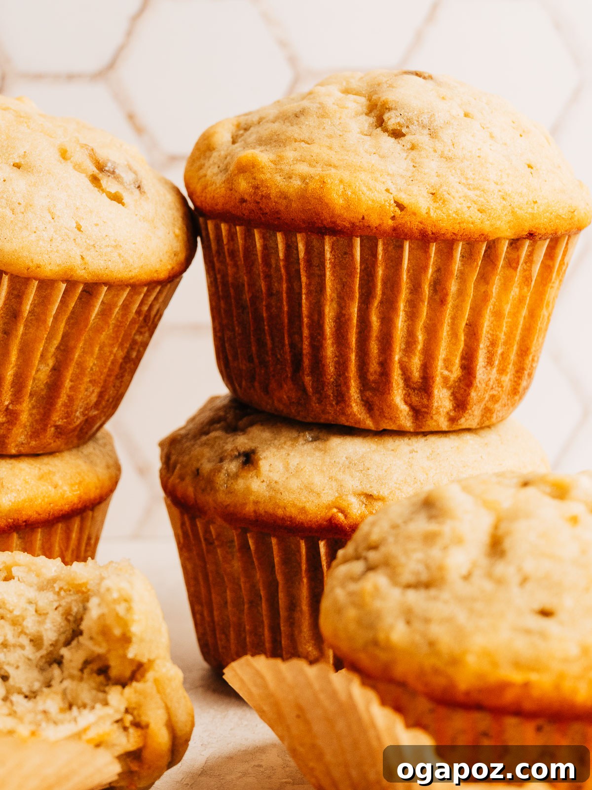 Moist Banana Bread Muffins That Stay Fresh for Days 8 Golden banana muffins stacked on a plate, ready to serve for breakfast.