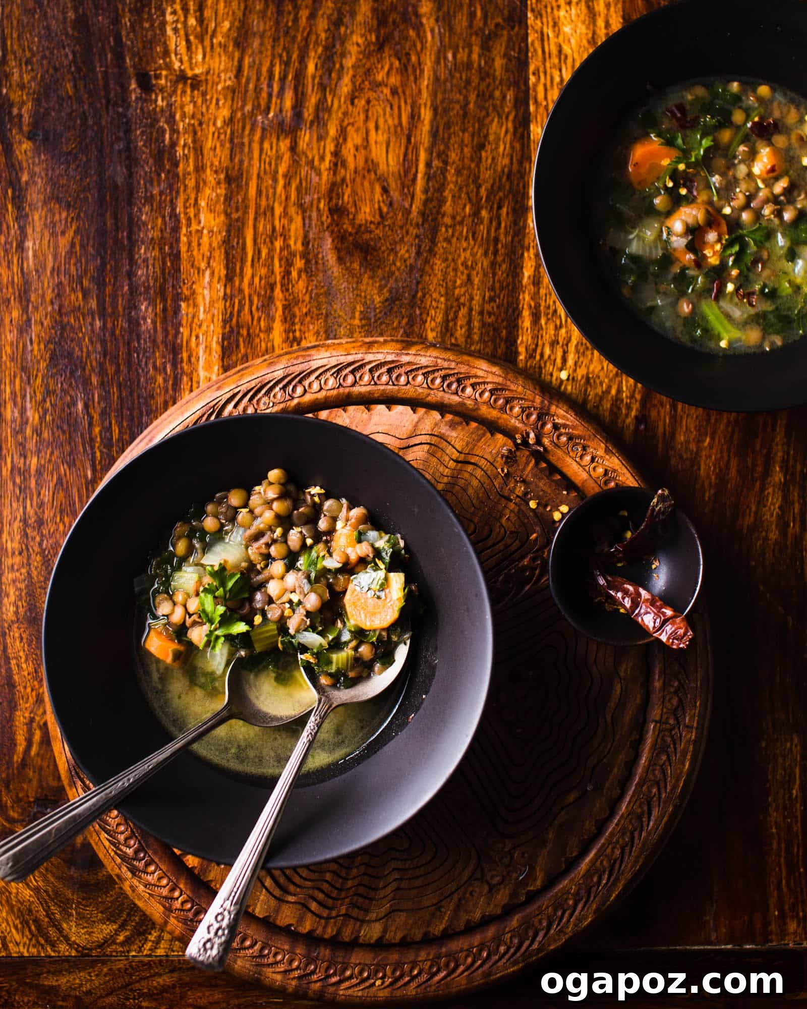 57 Simple Soup Recipes to Warm Your Soul 20 Hearty lentil and kale soup in a rustic bowl with a spoon.