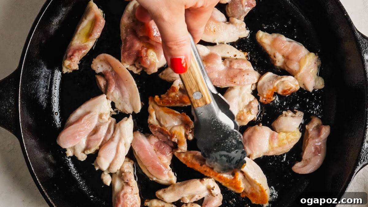 Creamy One-Pan Chicken Stroganoff 5 Searing chicken thigh strips in a hot skillet until golden brown.