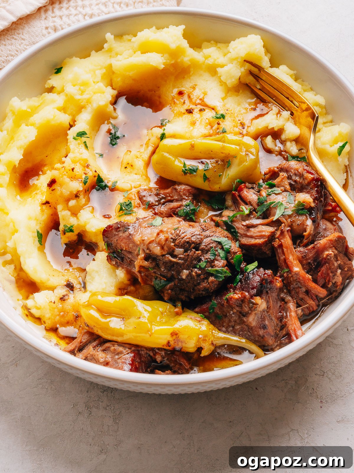 Slow-Cooker Mississippi Pot Roast Recipe for Tender, Flavorful Meat 2 Mississippi pot roast served over mashed potatoes with whole pepperoncini and parsley.
