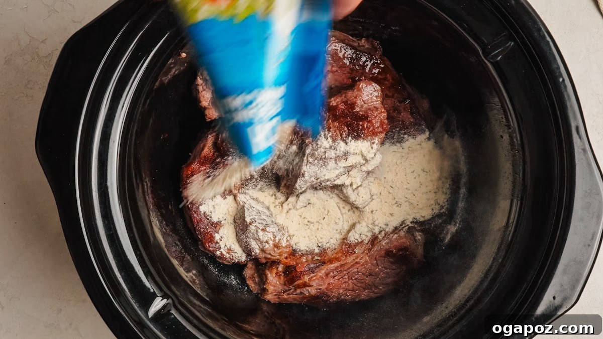 Slow-Cooker Mississippi Pot Roast Recipe for Tender, Flavorful Meat 5 Ranch and au jus seasoning packets sprinkled over the roast in the slow cooker.