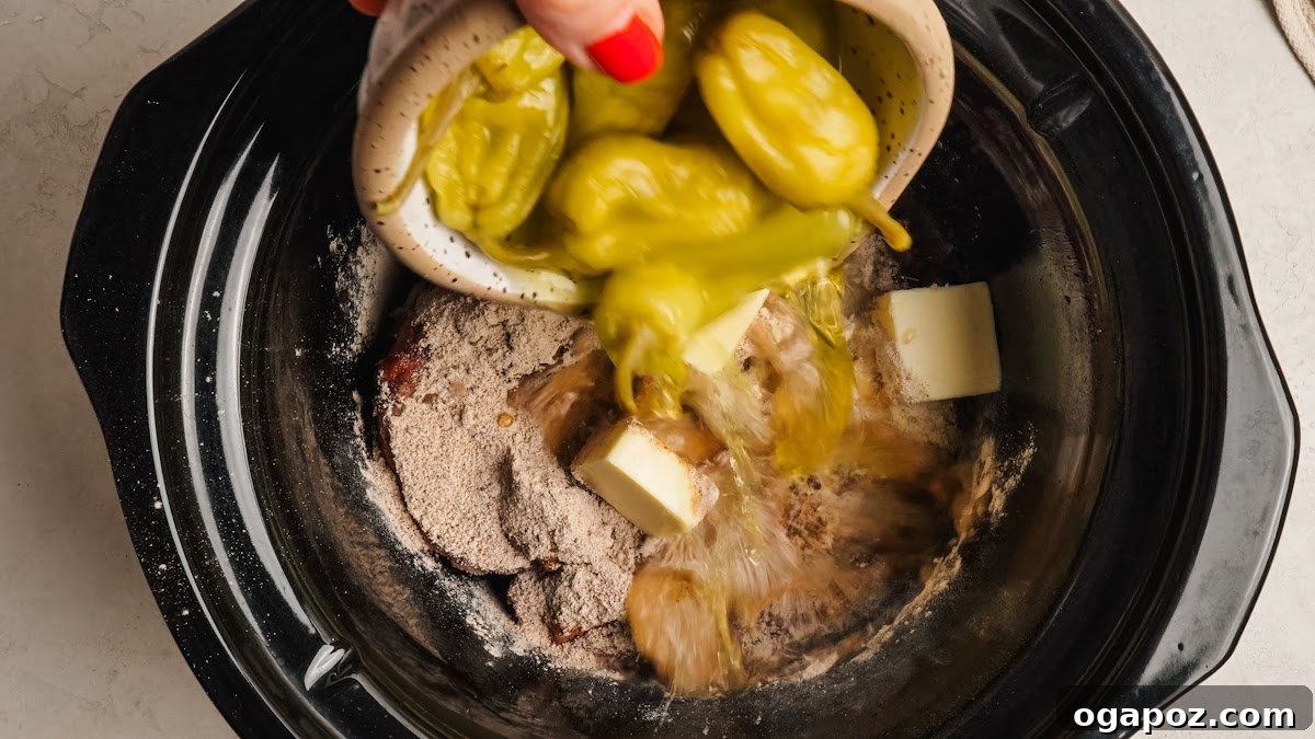 Slow-Cooker Mississippi Pot Roast Recipe for Tender, Flavorful Meat 6 Butter pieces and whole pepperoncini added on top of the roast.
