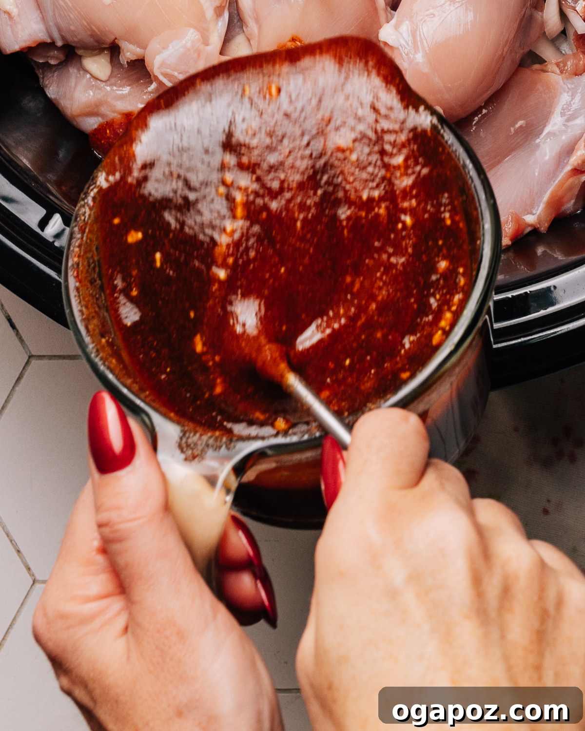 Pouring Sweet Honey BBQ sauce over chicken thighs.