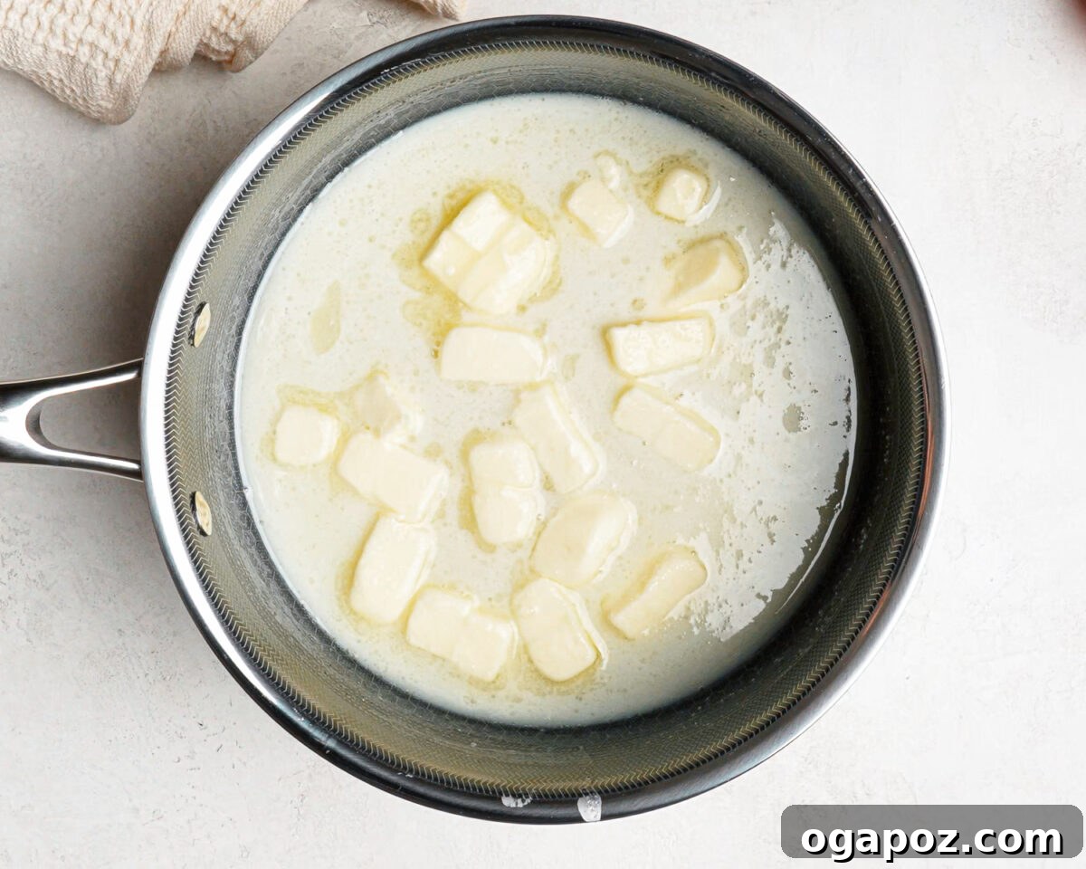 Sugar, corn syrup, heavy cream and cubed butter in a saucepan before boiling.