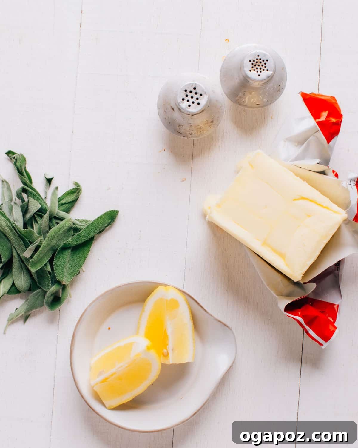 Salted butter, fresh sage leaves, lemon and black pepper laid out for brown butter sage sauce.