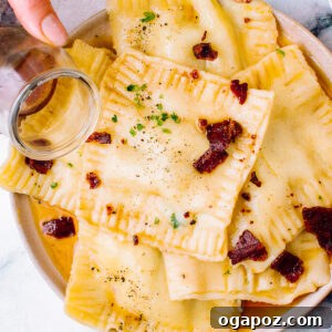 Plate of butternut squash ravioli tossed in brown butter sauce and sprinkled with herbs